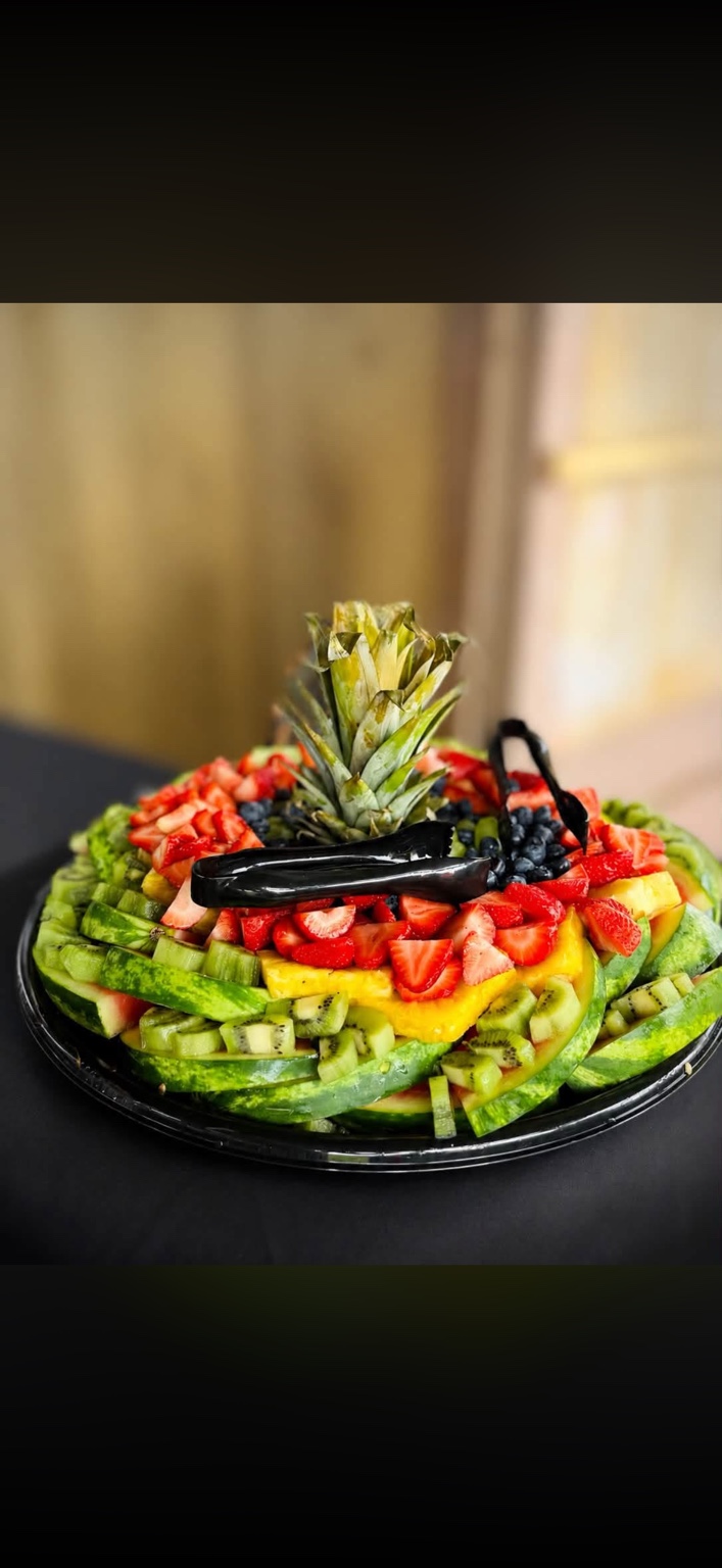 Layered watermelon, kiwi, pineapple, strawberries and blueberries on a fruit platter