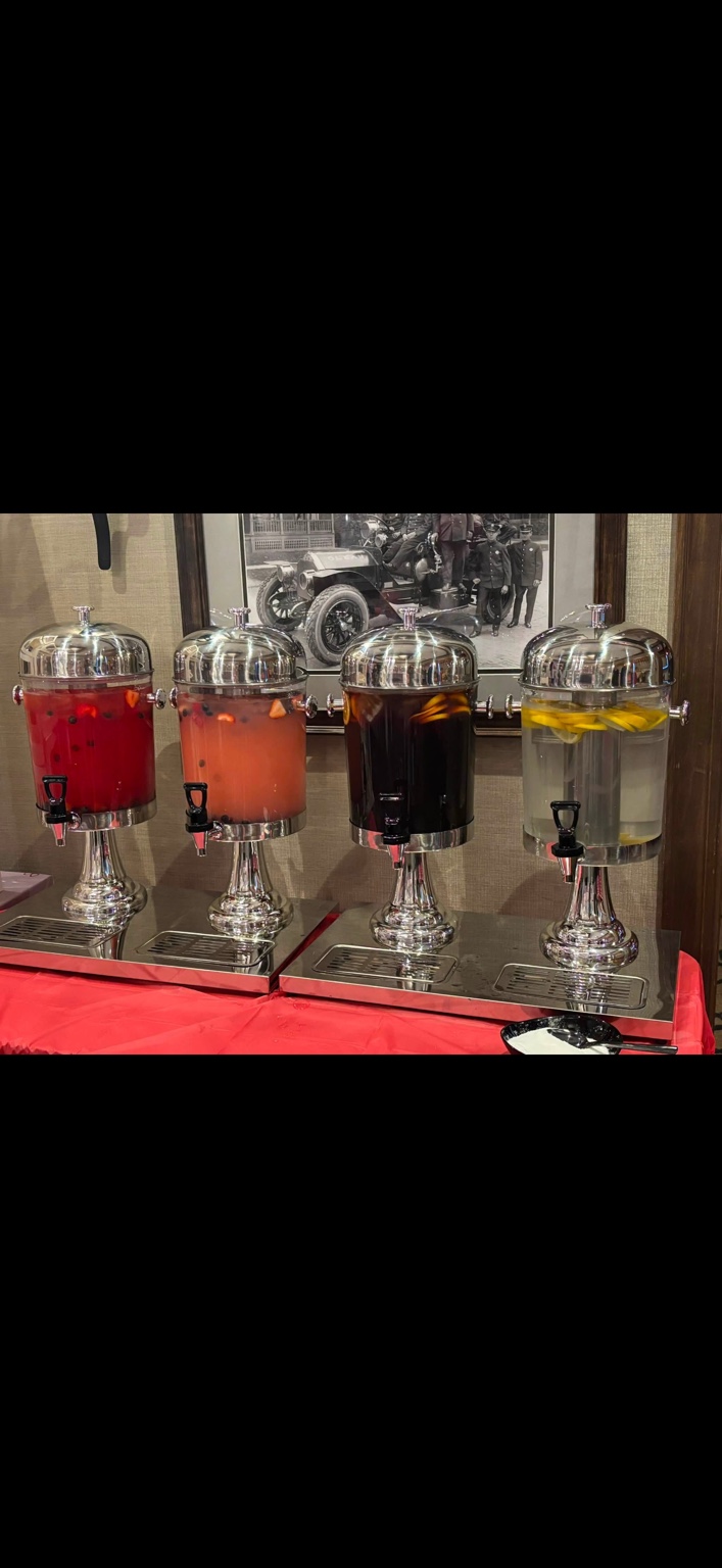 Four beverage dispensers with fruit garnishes