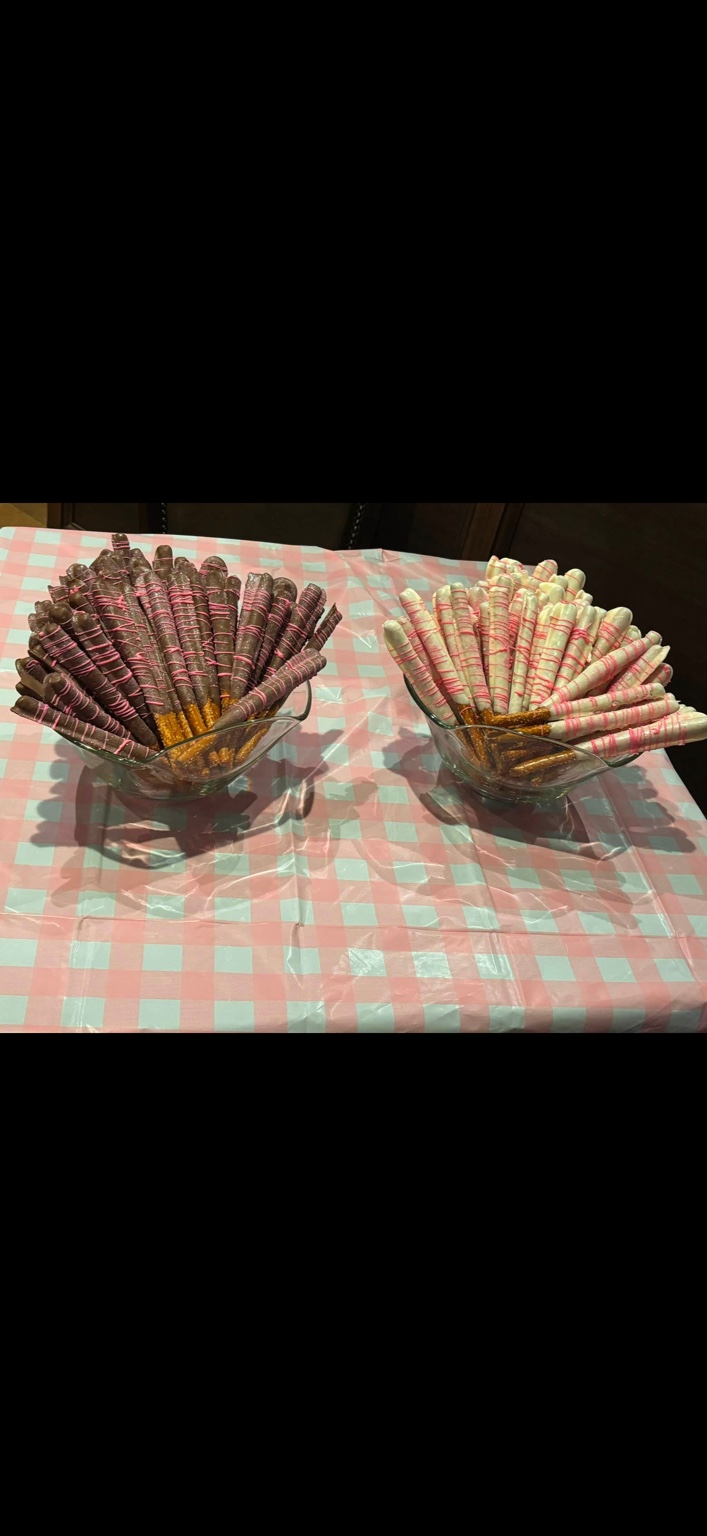 Chocolate-dipped pretzel rods with pink drizzle
