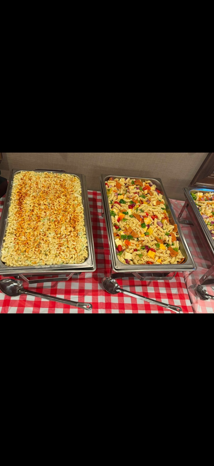 Buffet trays of macaroni salad and colorful pasta salad